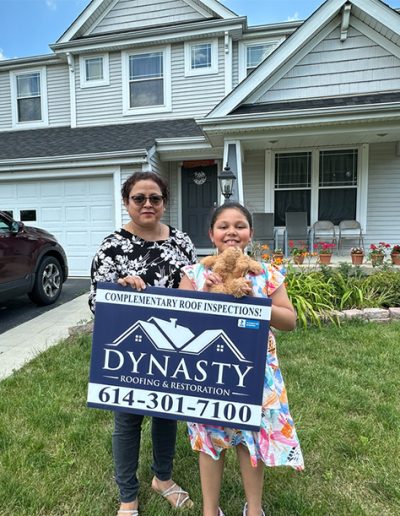 homeowners outside of their house with new gutters