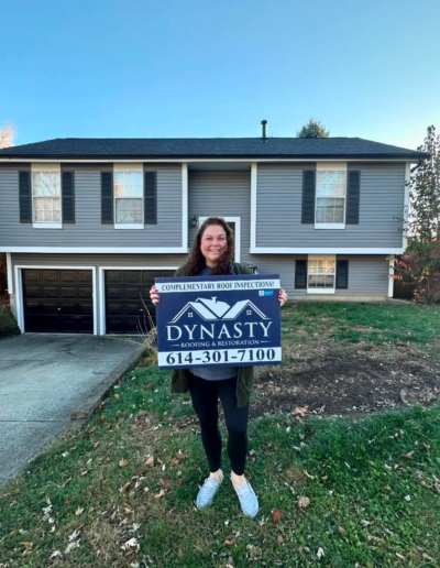 homeowner in front of house with new gutters