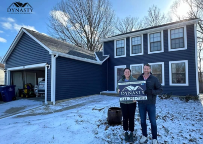 homeowners in front of their house with new blue siding